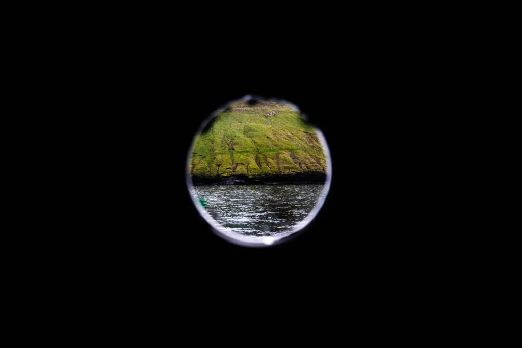 Faroe Islands cliff and ocean seen through a ship porthole