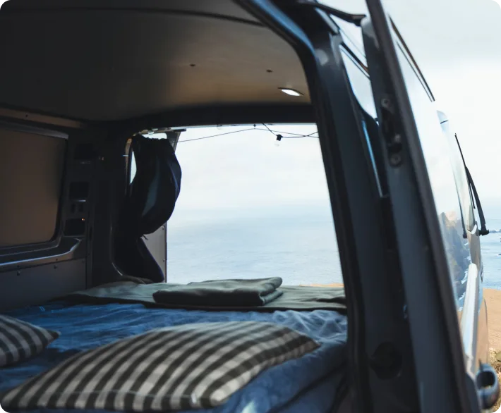 Mask group (20) VW Transporter campervan with open door overlooking sea cliffs in the Faroe Islands – Premium camper rental for 2–3 people