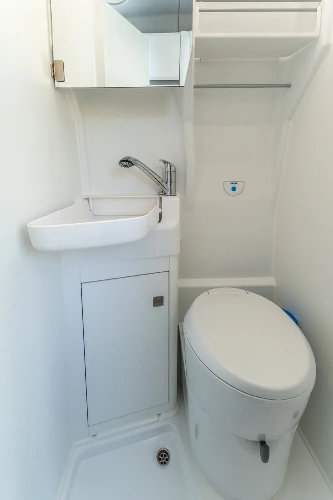 Compact campervan bathroom with toilet and sink