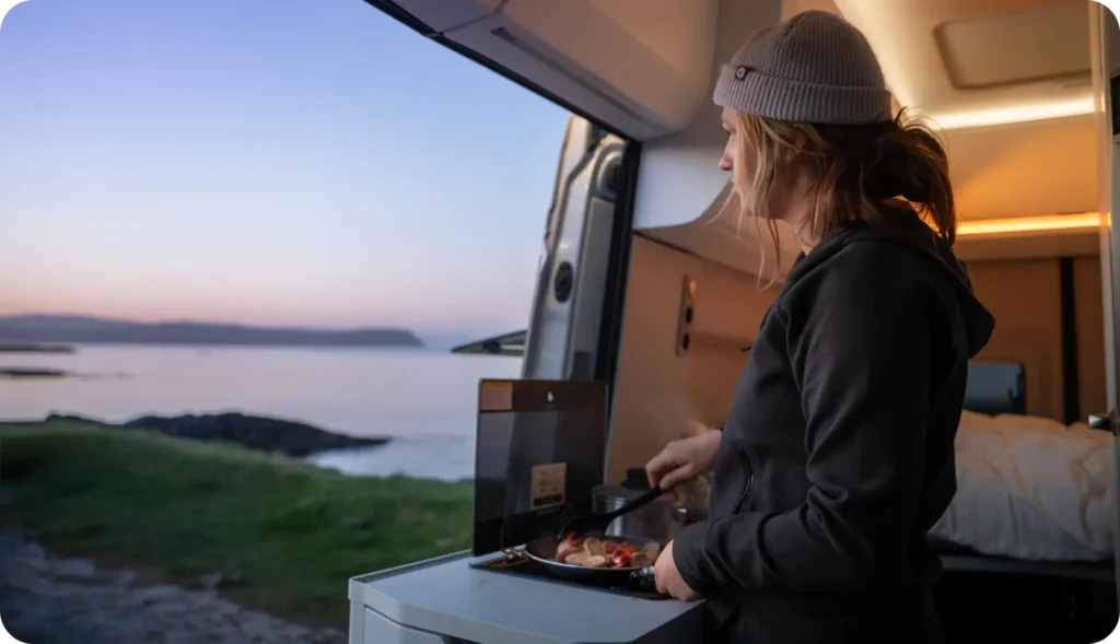 Faroe Islands camper van rental — cooking inside with panoramic coastal view