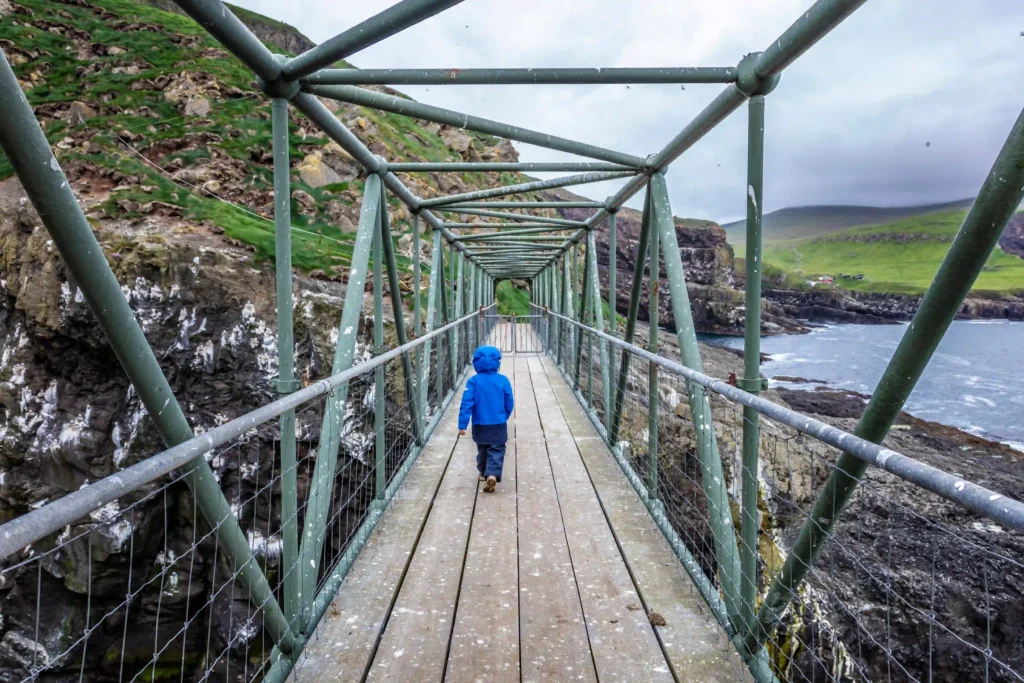 Child walking across a bridge on Mykines in the Faroe Islands